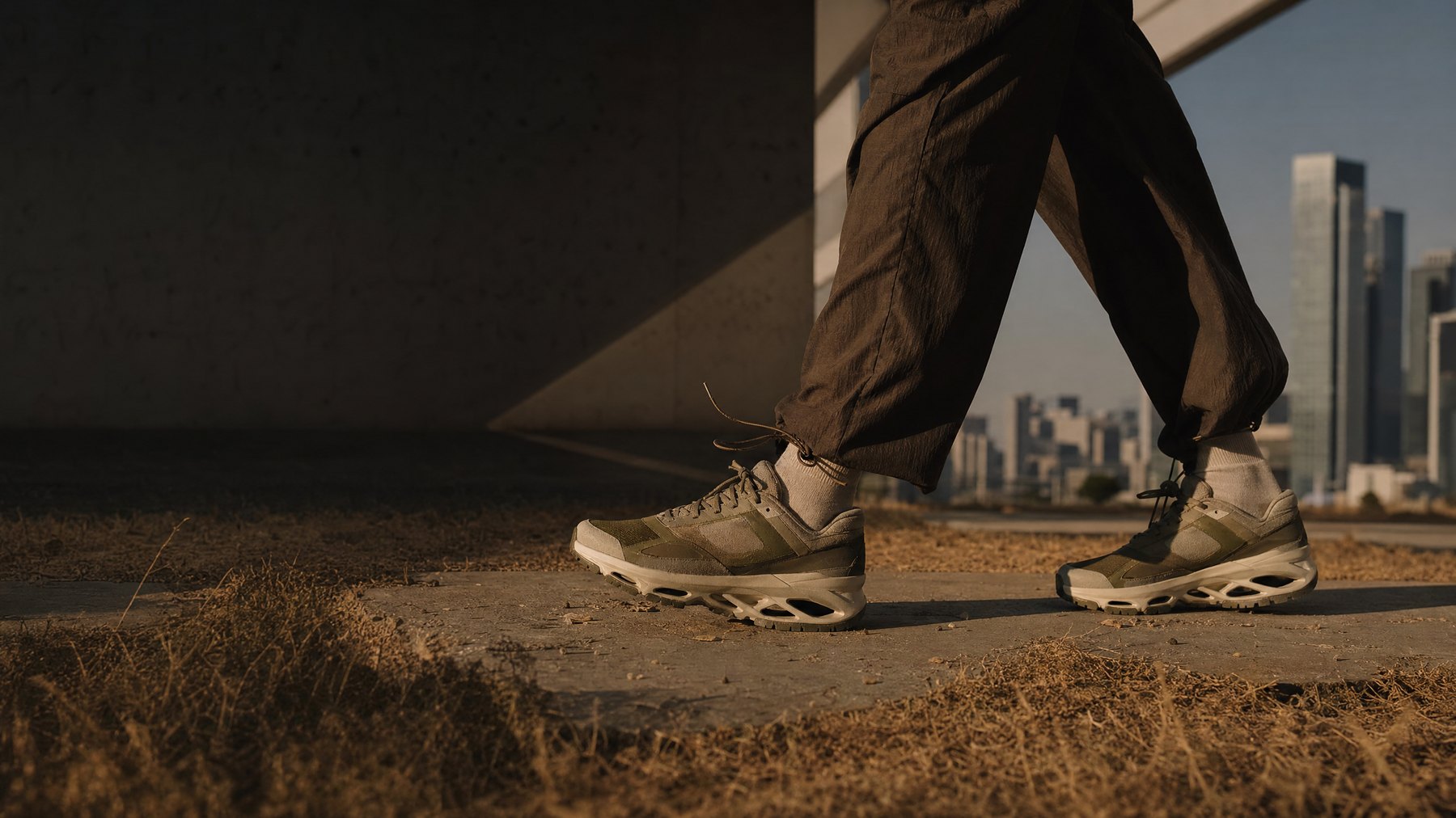 Runner wearing an olive technical sneaker across an urban trail